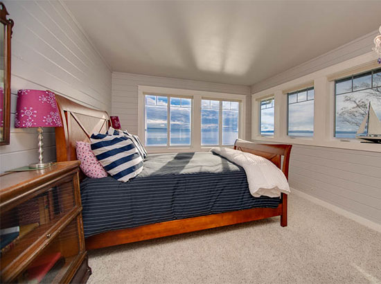 This nautically themed bedroom offers a queen sleigh bed looking out to fabulous water views.