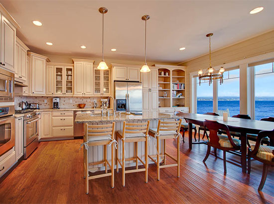 Spacious gourmet kitchen with a sweeping ocean view and natural lighting. The hammered cherry hardwood floors and soft lighting provide a relaxing setting for friends, family or coworker groups of up to 12 guests.