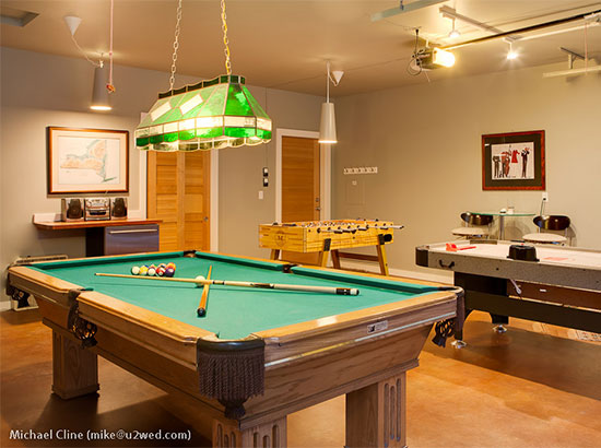 New game room has 8' slate Connelly pool table, professional foosball, and airhockey, along with a beverage fridge barstools, a couch and lounge chairs.