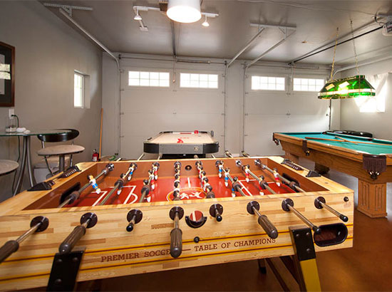 New game room has 8' slate Connelly pool table, professional foosball, and airhockey, along with a beverage fridge barstools, a couch and lounge chairs.